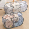 A gray foldable mesh laundry basket filled with folded white and light-colored clothing.