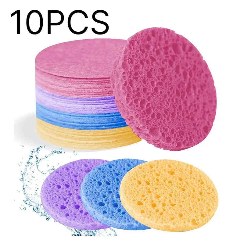 Esponjas de limpieza desechables naturales en rosa, azul y amarillo apiladas y esparcidas.