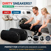 A man and a woman are shown using black reusable shoe laundry bags to wash sneakers in a washing machine.