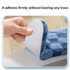 A hand firmly adheres a white cushion cover to a blue, fluffy toilet seat.