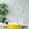 Goldfarweiche 3D-abstrakte Wanduhr mit Ziffern und Zeigern, montiert an einer hellgrauen Wand.