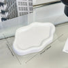 A white cloud-shaped jewelry organizer tray shown on a glass surface.