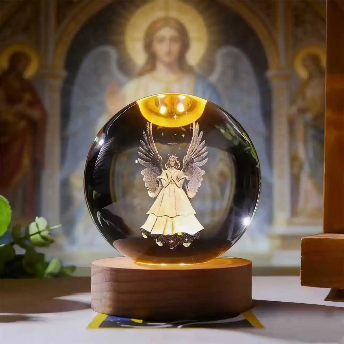 A dark glass crystal ball with a golden illumination rests on a wooden base, set against a religious background.