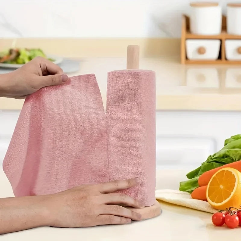 Hands are demonstrating a pink reusable microfiber cleaning cloth rolled up for use.