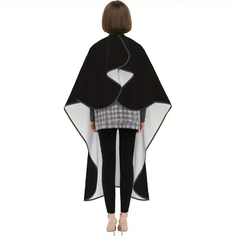 A black professional salon hair cutting cape with a gray patterned apron and adjustable neck closure.