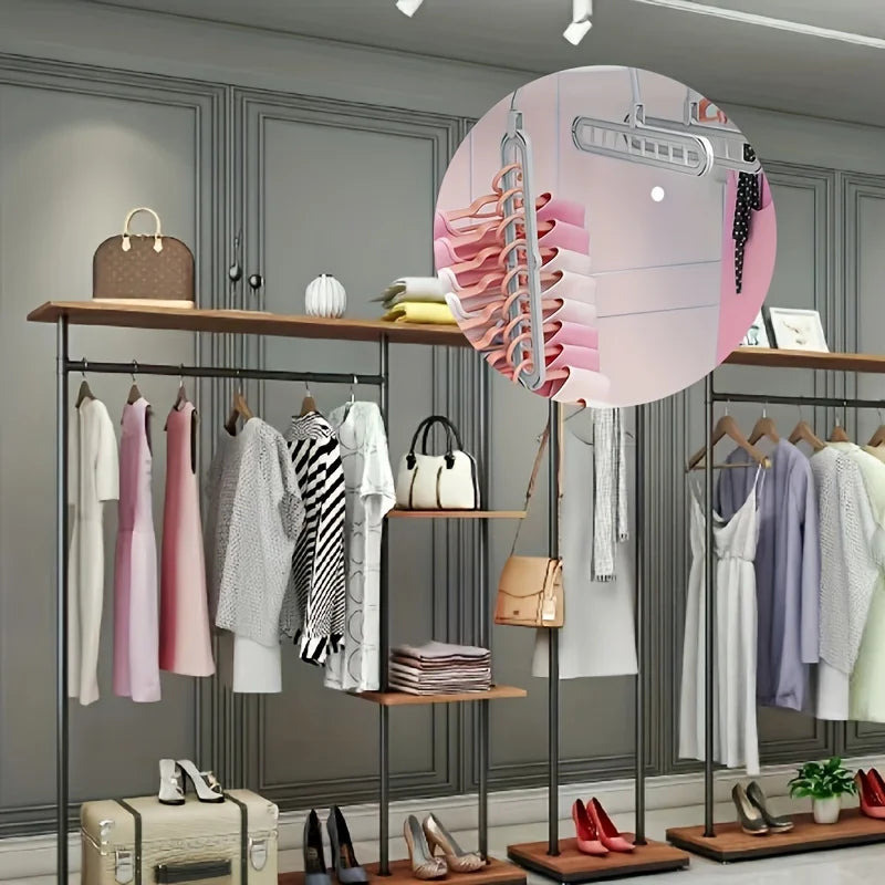 A display of foldable plastic hangers in various colors and sizes on a wooden rack.
