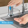 Hand pressing a stainless steel under-sink soap dispenser with an extension tube onto a sink basin.