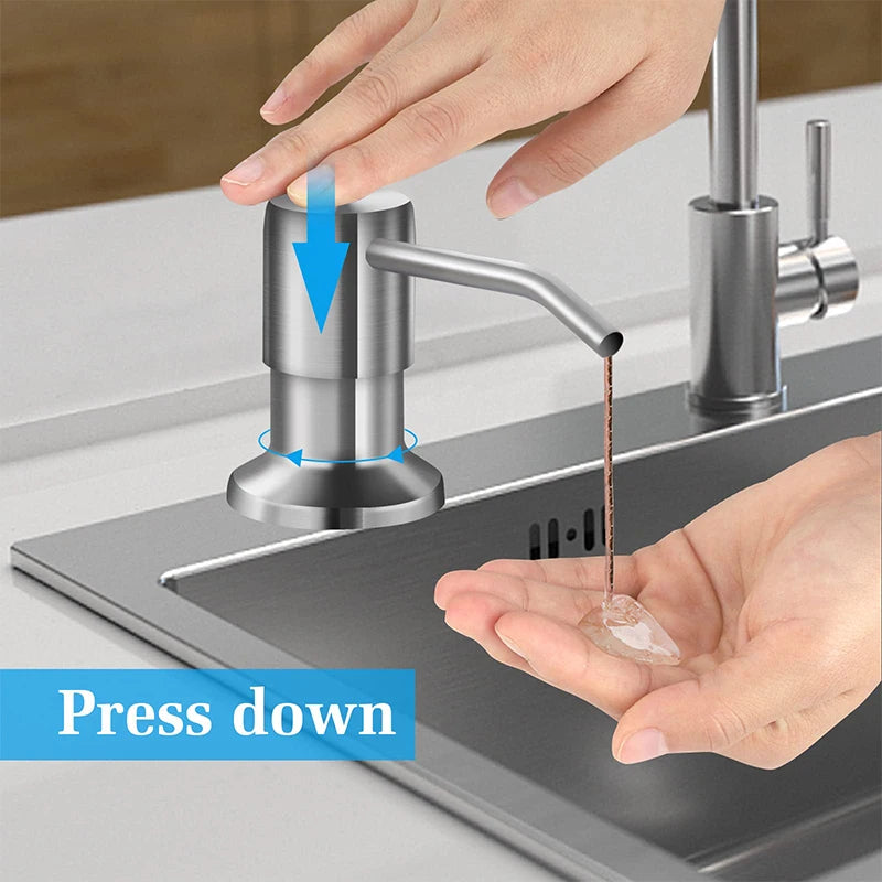 Hand pressing a stainless steel under-sink soap dispenser with an extension tube onto a sink basin.