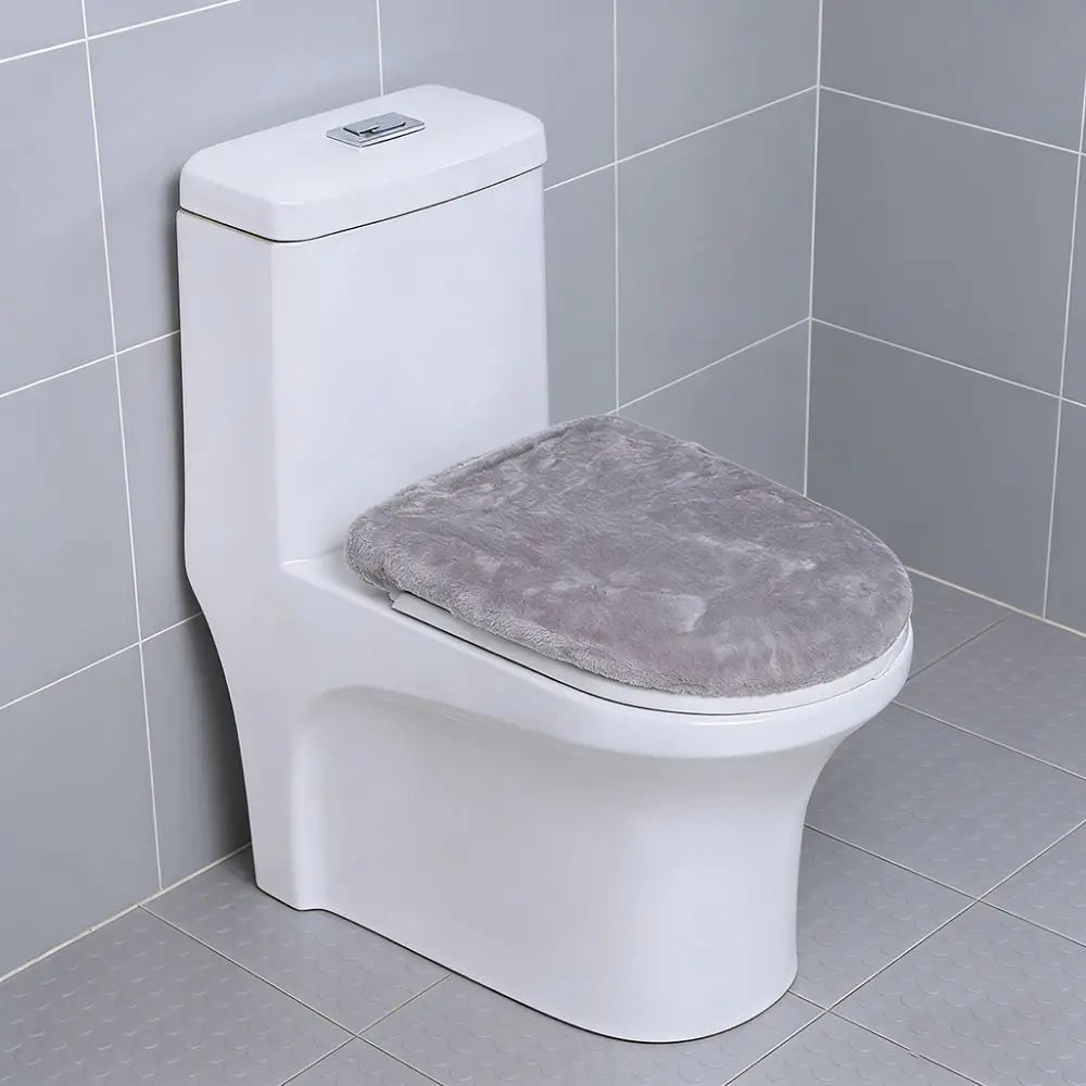 A white toilet with a gray protective seat cover installed in a bathroom setting.