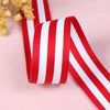 Red and white striped grosgrain ribbon rolled and laid on a light pink surface.