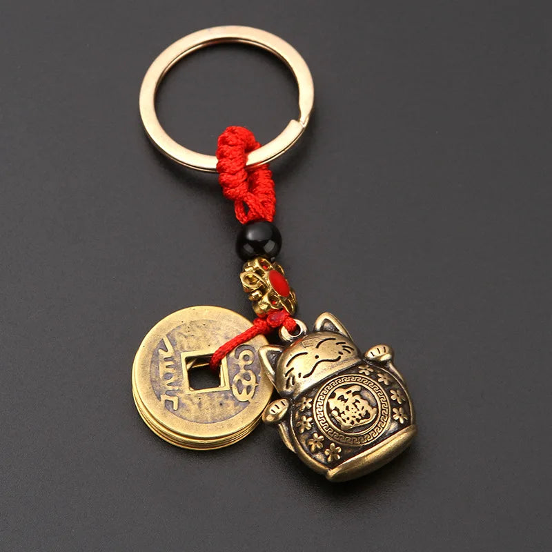 Vintage gold-tone lucky cat keychain with a red tassel and gold-toned circular charm