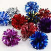 Eine Sammlung farbenfroher Pom-Pom-Anhänger in verschiedenen Schattierungen einschließlich blau, rot, lila und silber.