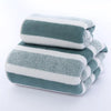 A stack of three striped microfiber bath towels in shades of gray and white.
