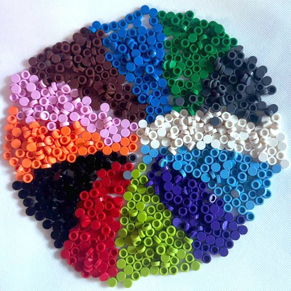 A colorful arrangement of round building blocks in various shades including blue, green, purple, red, and black.