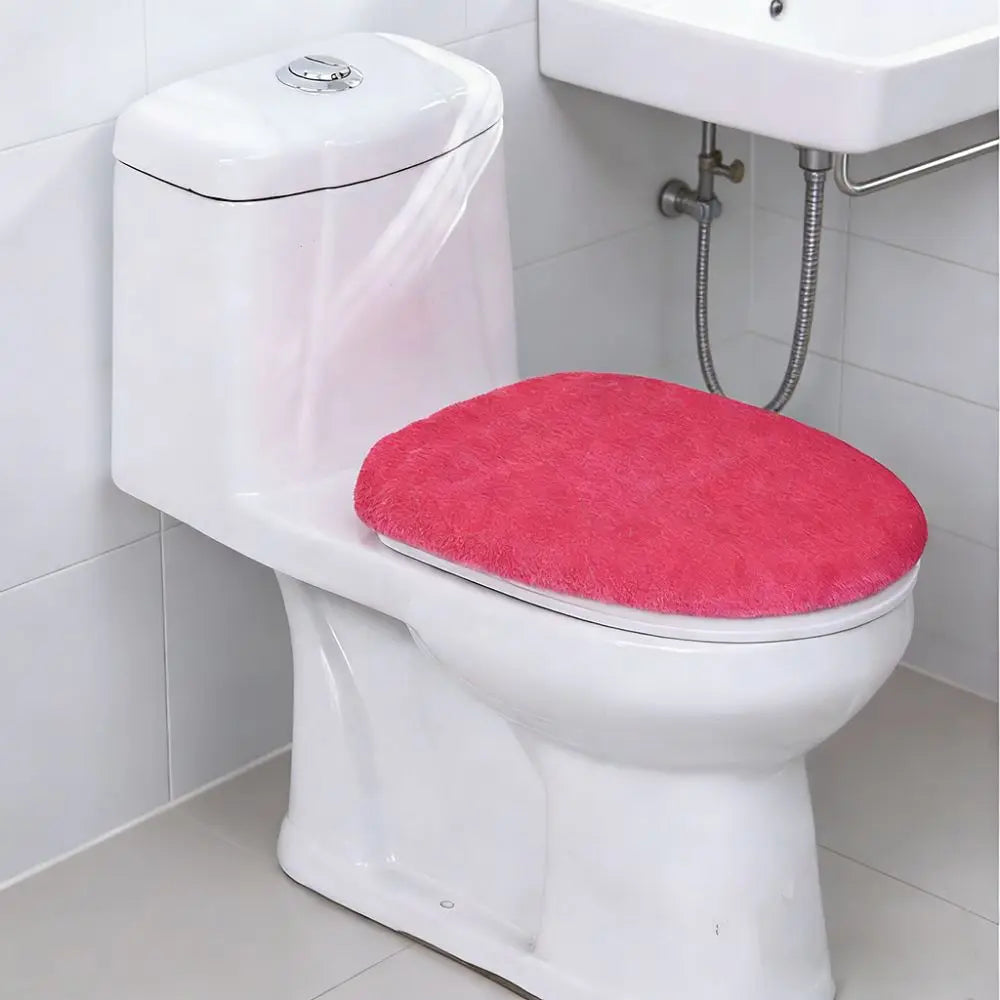 A white toilet with a bright pink protective seat cover installed on it.