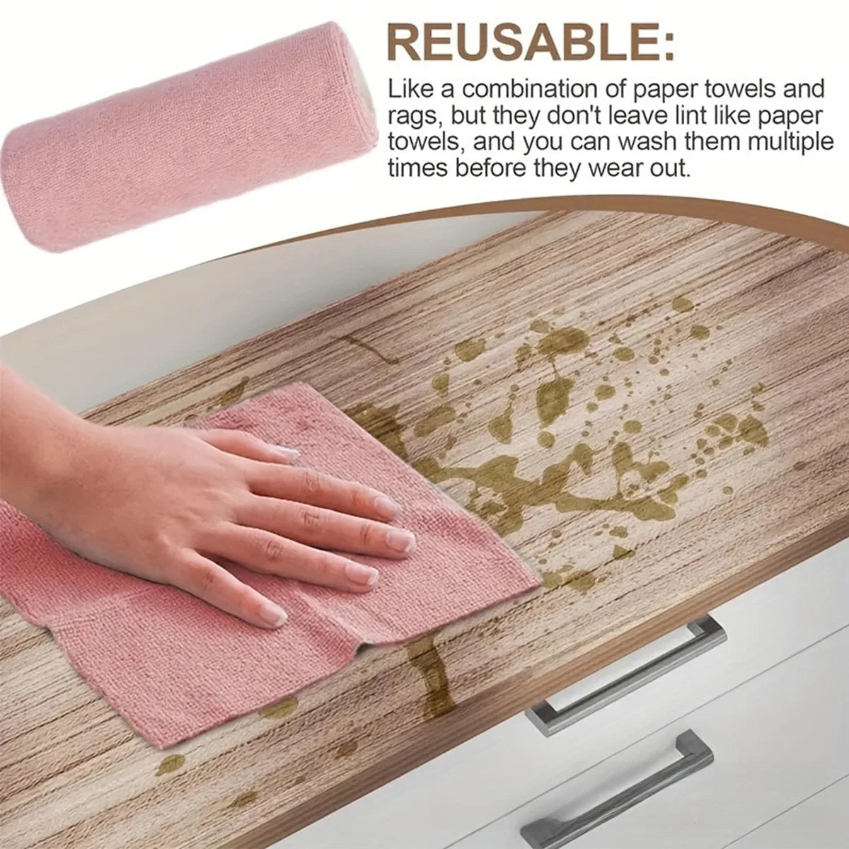A pink reusable cleaning towel is being used to wipe up spilled liquid on a wooden table surface.