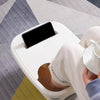 A white foldable foot soak bucket is shown with a black screen, resting on a gray patterned floor.
