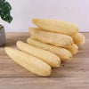 A stack of natural yellow loofah exfoliating body sponges with hanging ropes on a wooden surface.