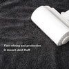 A roll of white microfiber cleaning towels placed on a dark textured fabric with text about fine editing and production.