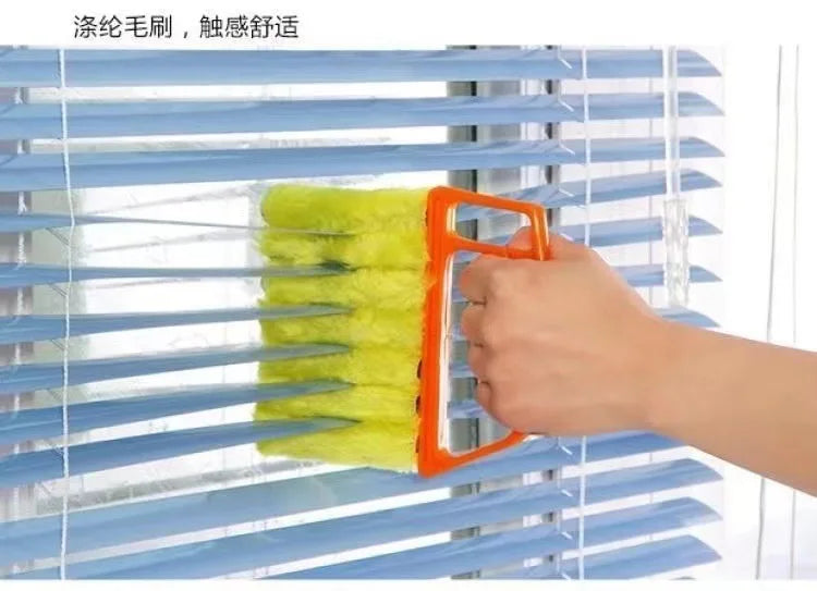 An orange cleaning brush is shown cleaning the slats of a blue blind.