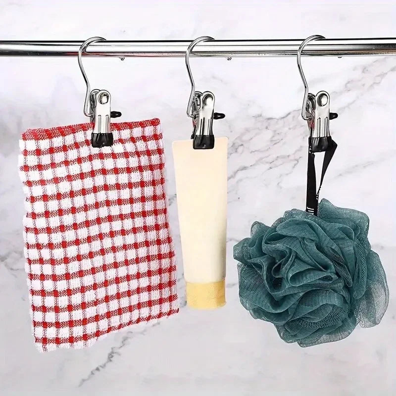 Stainless steel clothespins holding a red checkered cloth, a yellow bar, and a teal fabric flower.