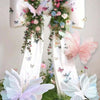 White ribbon decoration featuring pink and purple butterflies and floral greenery