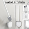 Une brosse à toilette en silicone blanche est accrochée au mur, montrant son utilisation pratique et son design économe en es