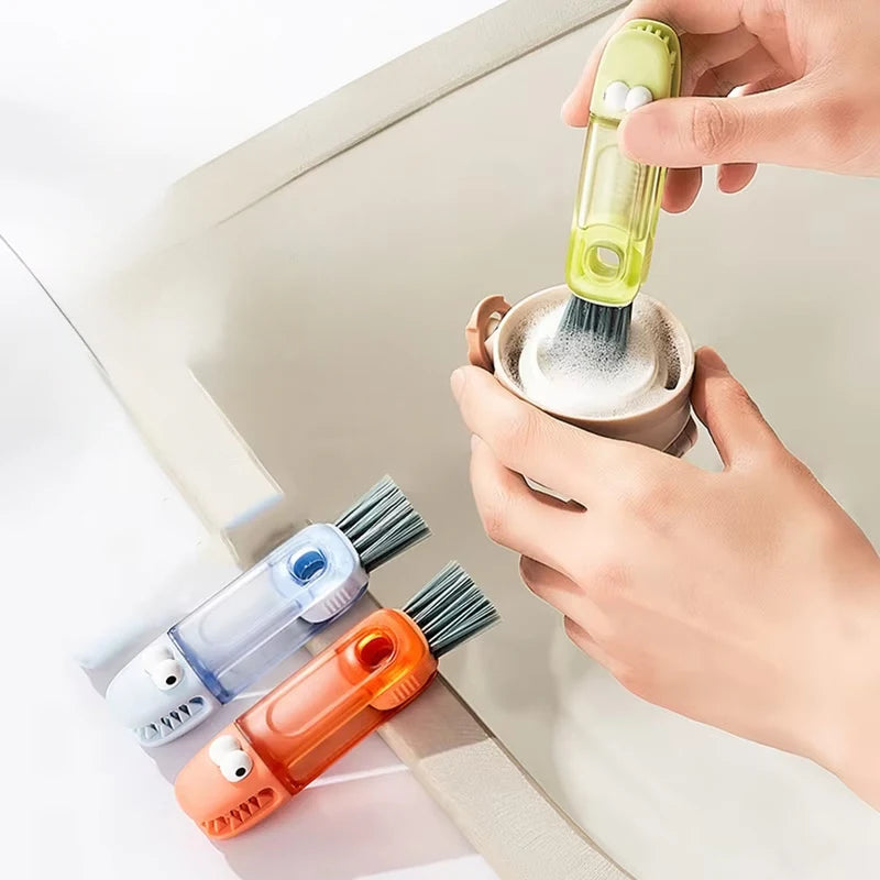 A hand is using a yellow cleaning brush to clean a surface, with other brushes visible nearby.