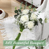 A bouquet of white roses and baby's breath flowers tied with a sheer ribbon on a white linen cloth.