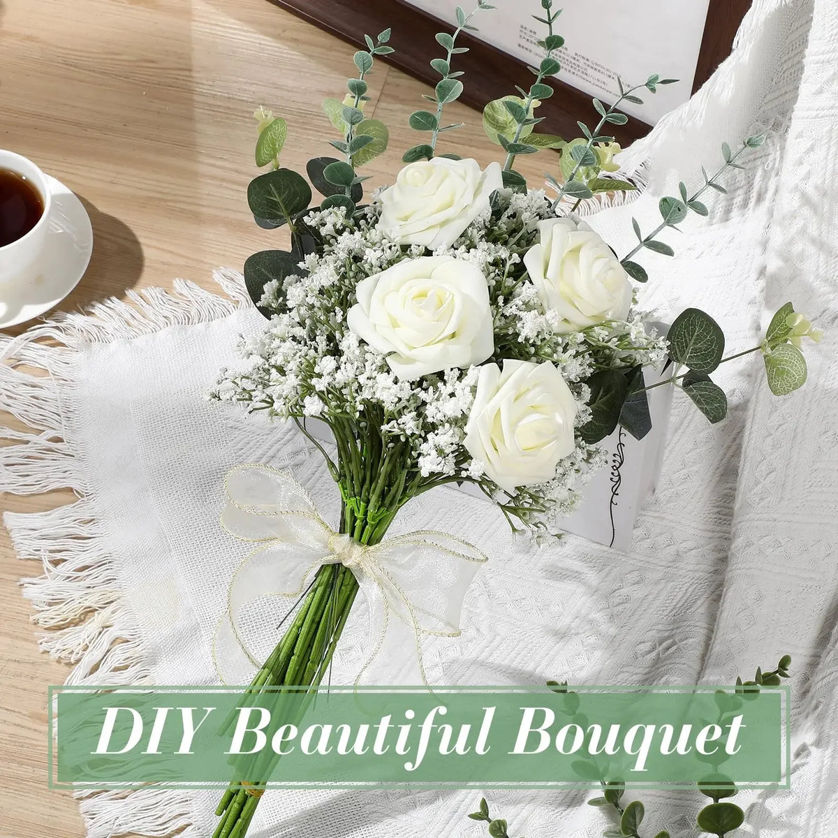 A bouquet of white roses and baby's breath flowers tied with a sheer ribbon on a white linen cloth.