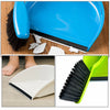 A blue mini handheld dustpan and brush set is shown cleaning a desk surface, with separate white cleaning pads visible.