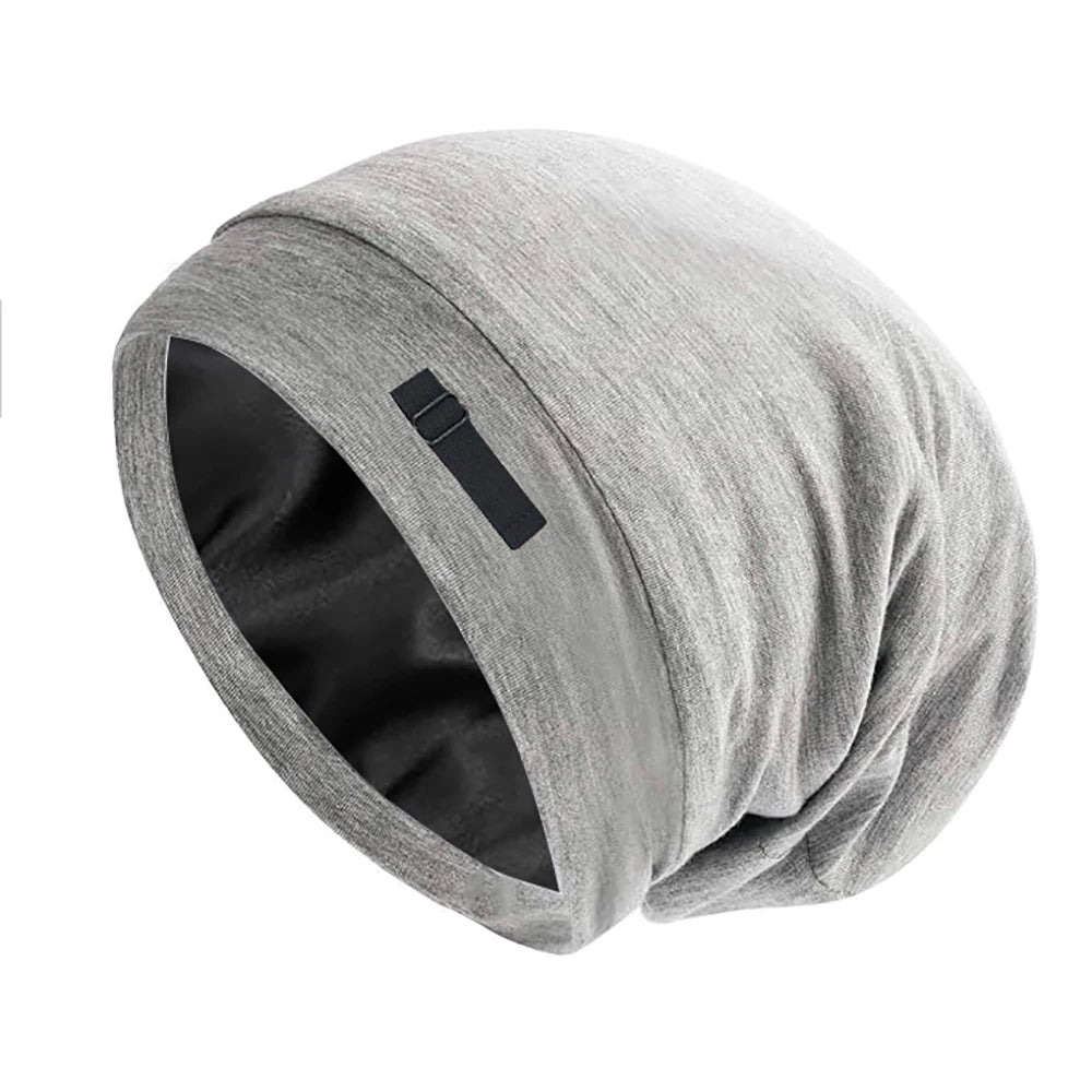 A gray adjustable silk-lined night cap rolled up, showing the interior lining.