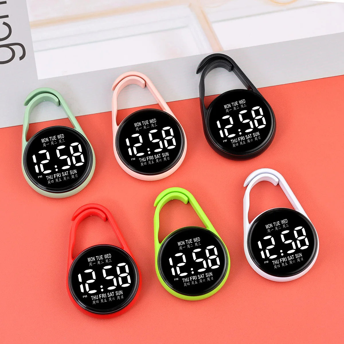 A collection of digital LED hanging pocket watches in black, pink, and green on a coral background.