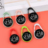 A collection of digital LED hanging pocket watches in black, pink, and green on a coral background.