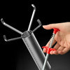 A hand holds a heavy duty sink and drain unclogging tool with a metal plunger and a red handle against a black background.