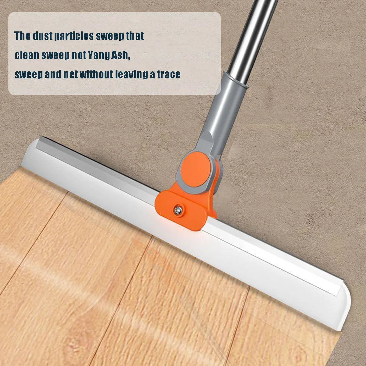 A silicone squeegee broom with an aluminum handle is shown sweeping dust particles across a wooden surface.