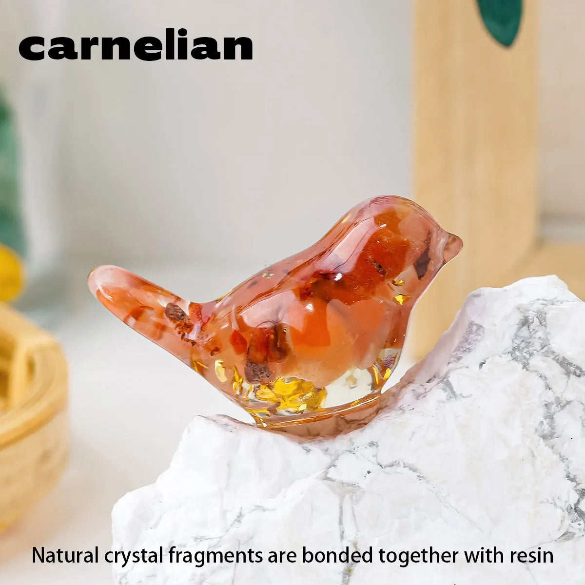 A small, amber-colored crystal bird statue is placed on a white marble surface.