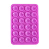 A pink silicone suction cup phone stand with multiple circular grips for hands-free viewing.