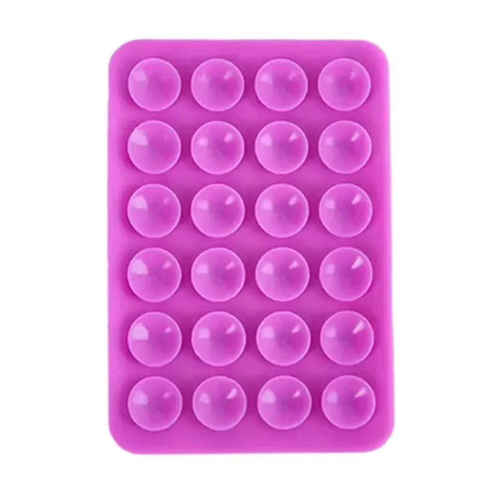 A pink silicone suction cup phone stand with multiple circular grips for hands-free viewing.