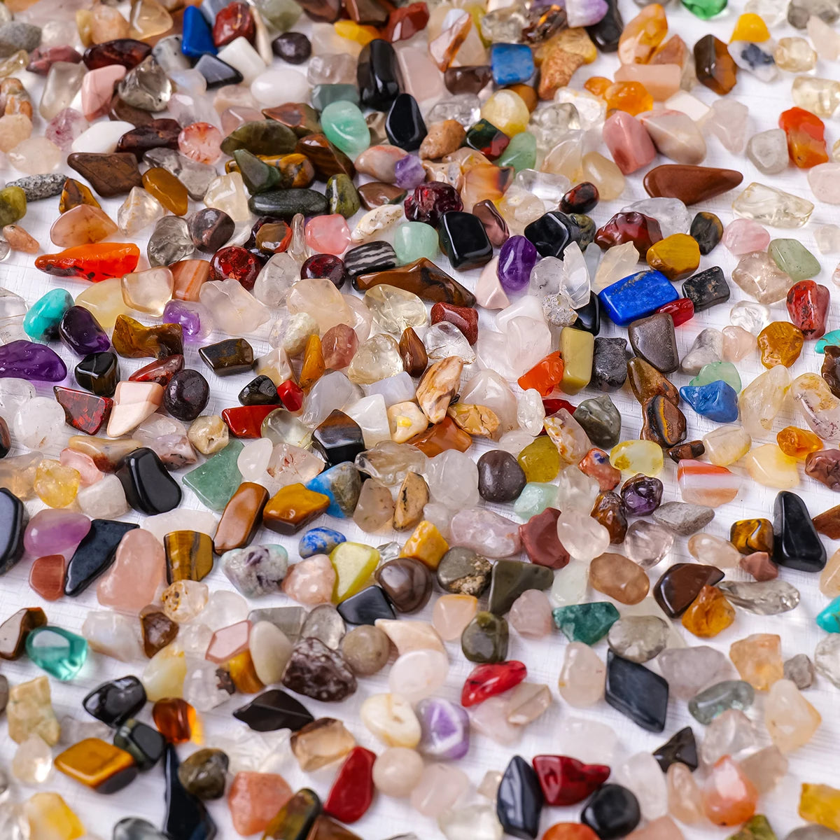 Gros plan de gravier de cristal naturel de différentes couleurs : rose, violet, bleu et ambre.