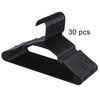A set of thirty black plastic clothes hangers with a curved hook design.