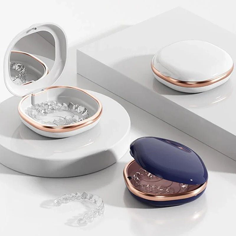 A set of compact dental retainer cases featuring built-in mirrors and storage containers in white and rose gold tones.