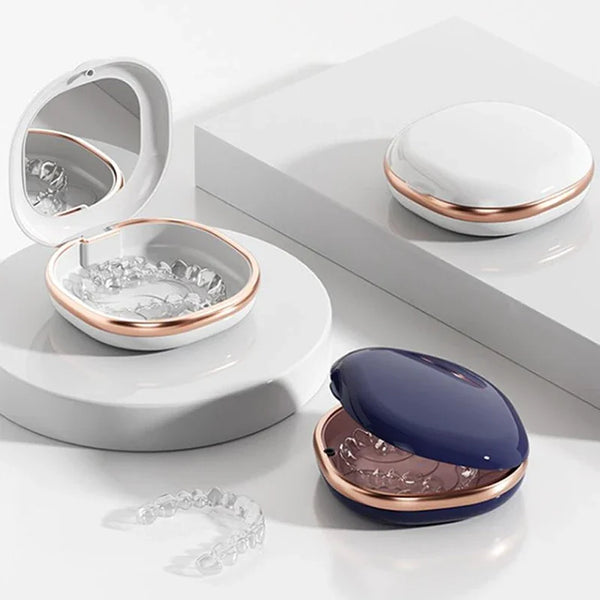 A set of compact dental retainer cases featuring built-in mirrors and storage containers in white and rose gold tones.