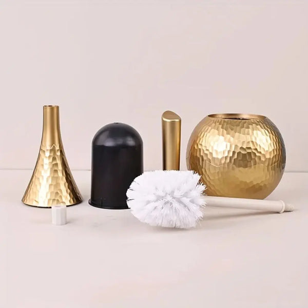 A set of gold and black cleaning brushes and a golden spherical brush head on a white surface.