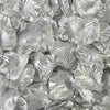 Pila de pétalos de rosa de seda artificial en varios tonos de gris y plata.