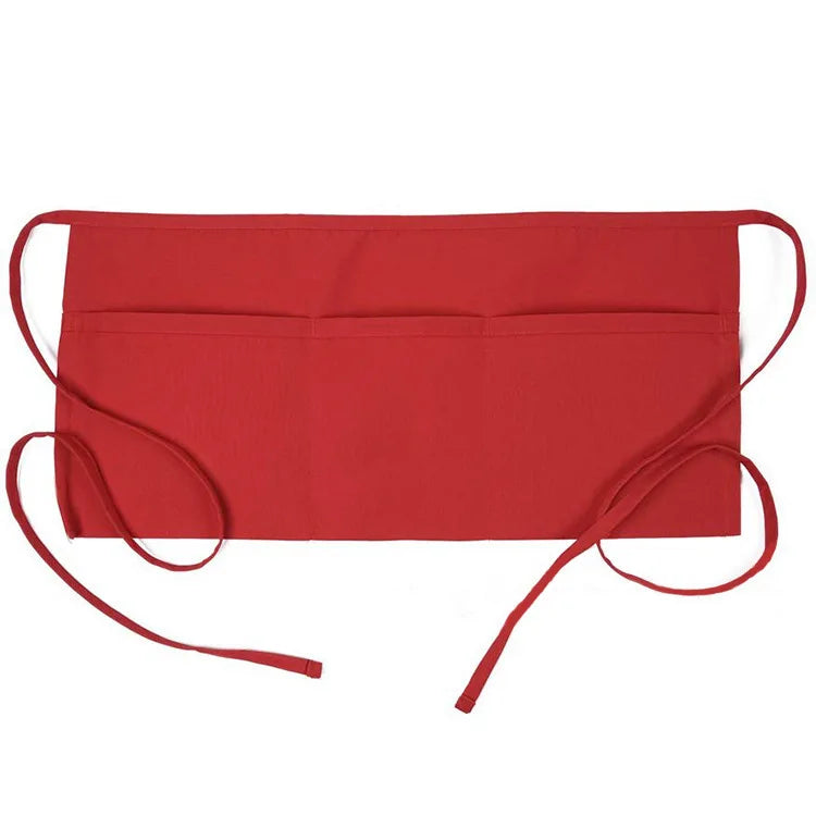 A bright red fashion chef short apron with pockets shown flat.
