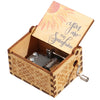 A vintage engraved wooden music box with a lid showing a sun design and a small metal mechanism inside.