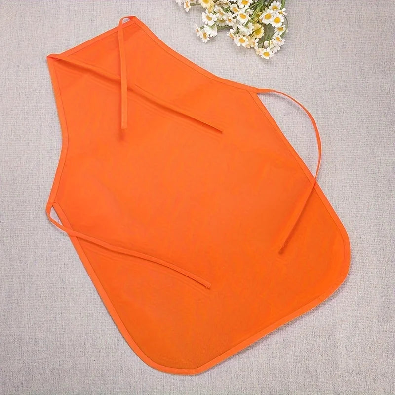 Orange non-woven craft apron laid flat on a light gray fabric with a small white flower in the background.