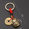 Vintage gold-tone lucky cat keychain featuring a circular tag and a cat charm on a red cord.