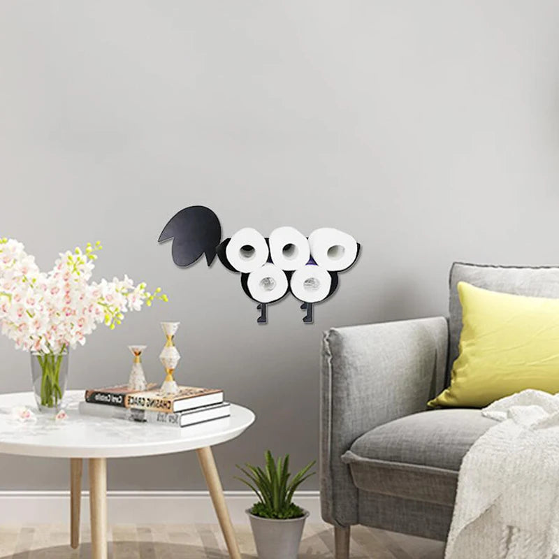 A black novelty animal toilet paper holder and storage rack displayed on a white table next to a gray armchair.
